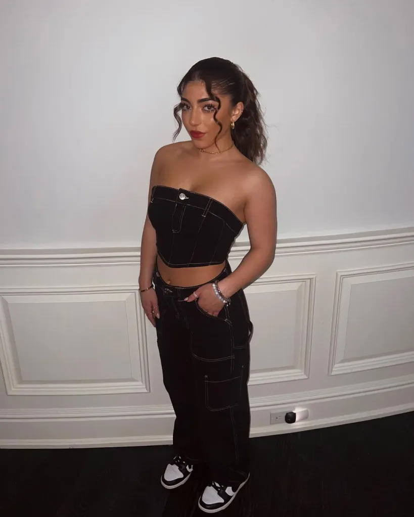Milania Giudice standing in a black strapless top and black pants.