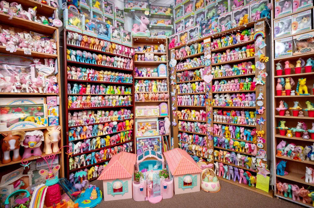 A room filled with shelves of various My Little Pony figurines, some still in boxes.