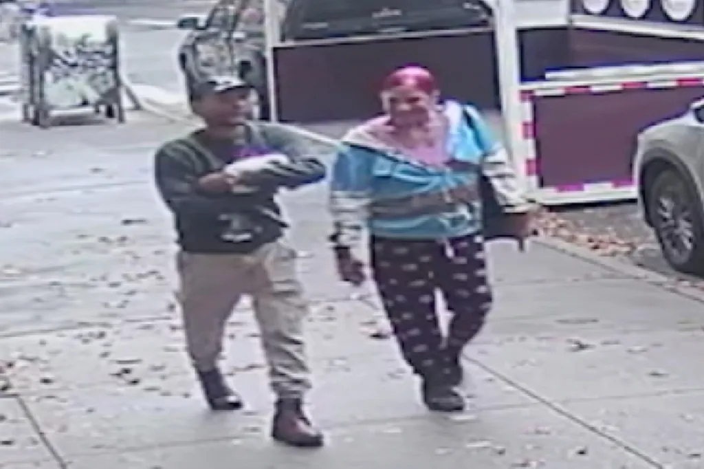 Surveillance photo of a man and woman walking down a sidewalk.