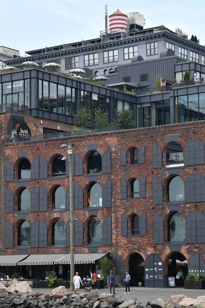 The Time Out Market food hall in DUMBO, with its large black and white striped awning and brick exterior, is closed.