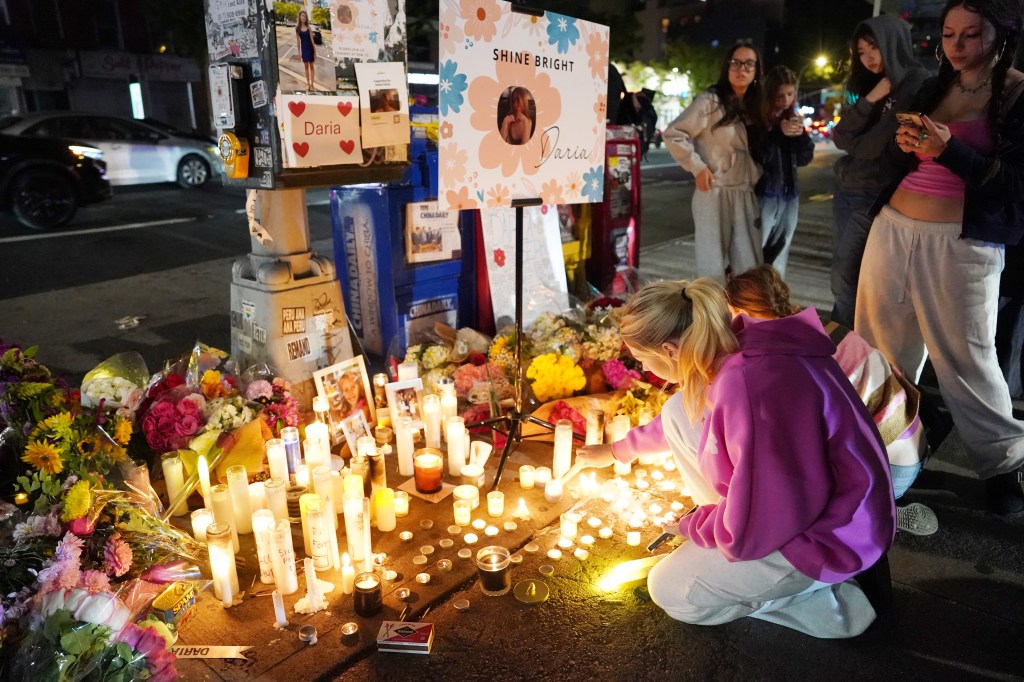 Mourners attend a candlelight vigil for Daria Serkov with photos, flowers, and candles.