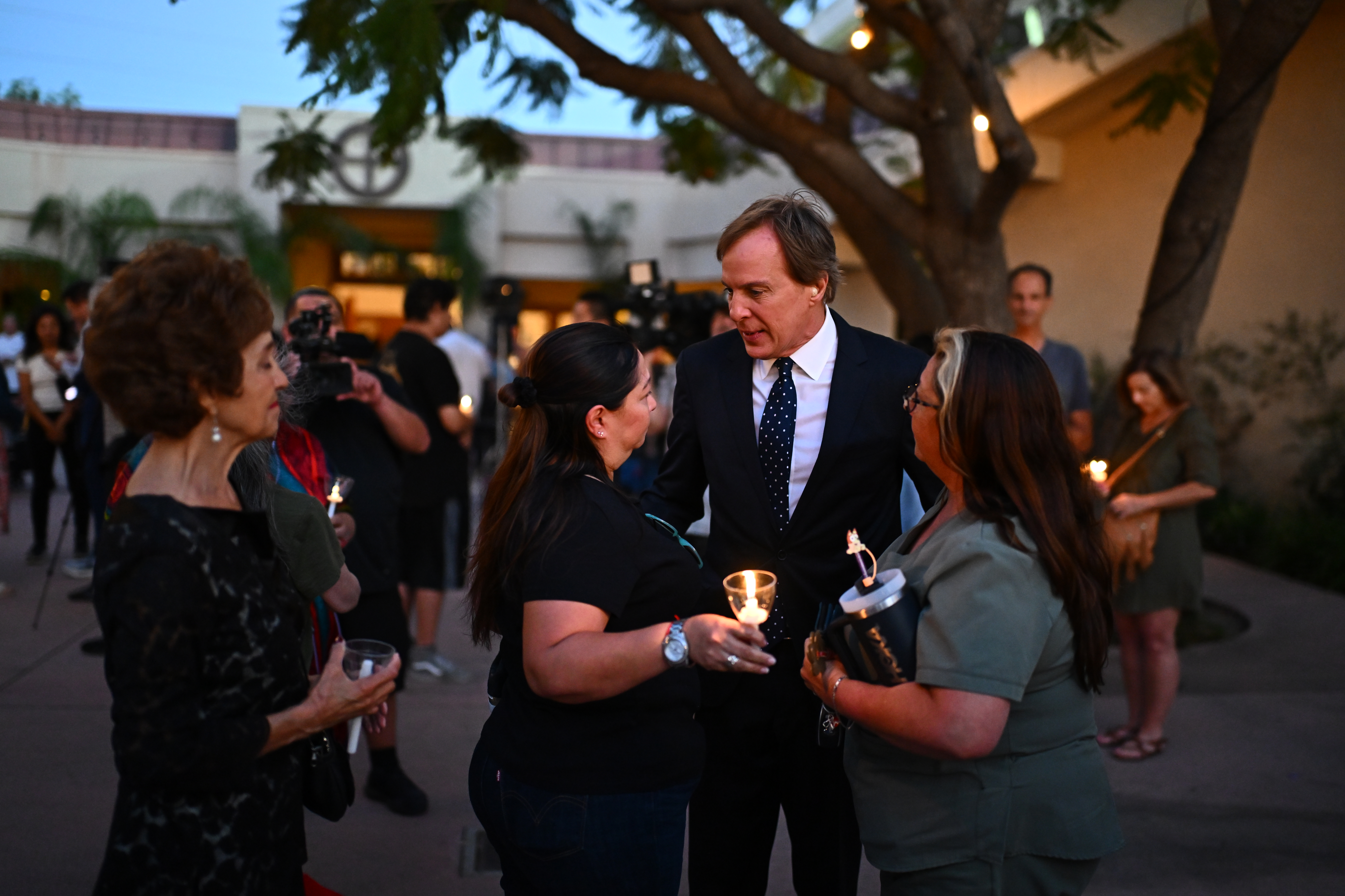 NBC journalist Robert Kovacik speaking with people holding candles at a vigil.