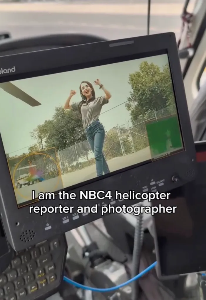 Screen showing Eliana Moreno with arms raised, from inside a helicopter.