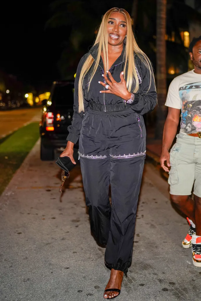 NeNe Leakes in a black tracksuit and black heels.