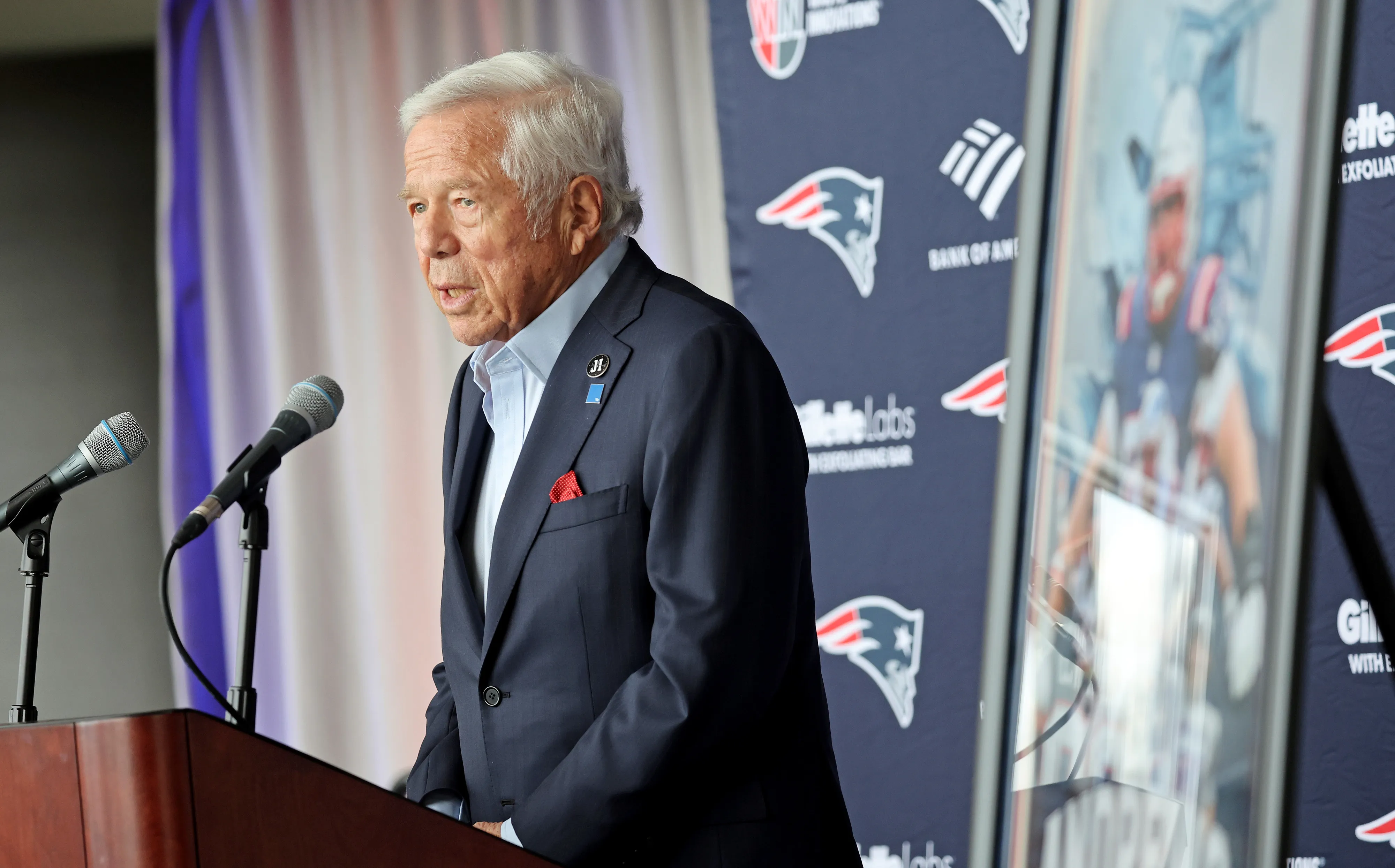 New England Patriots owner Robert Kraft speaking at a podium.