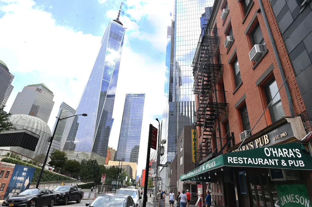 O'Hara's Restaurant & Pub, a brick building with a green awning, stands in front of modern skyscrapers including the Freedom Tower.