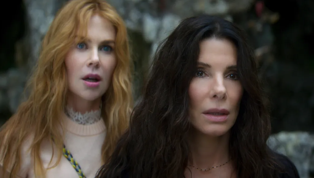Nicole Kidman with long red hair and Sandra Bullock with long dark hair, both looking forward.
