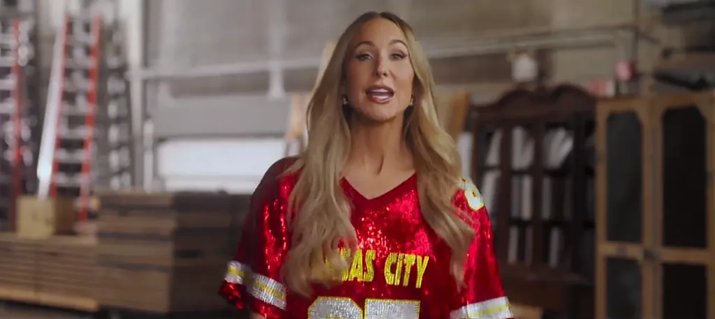 Nikki Glaser wearing a sequined Kansas City Chiefs shirt.