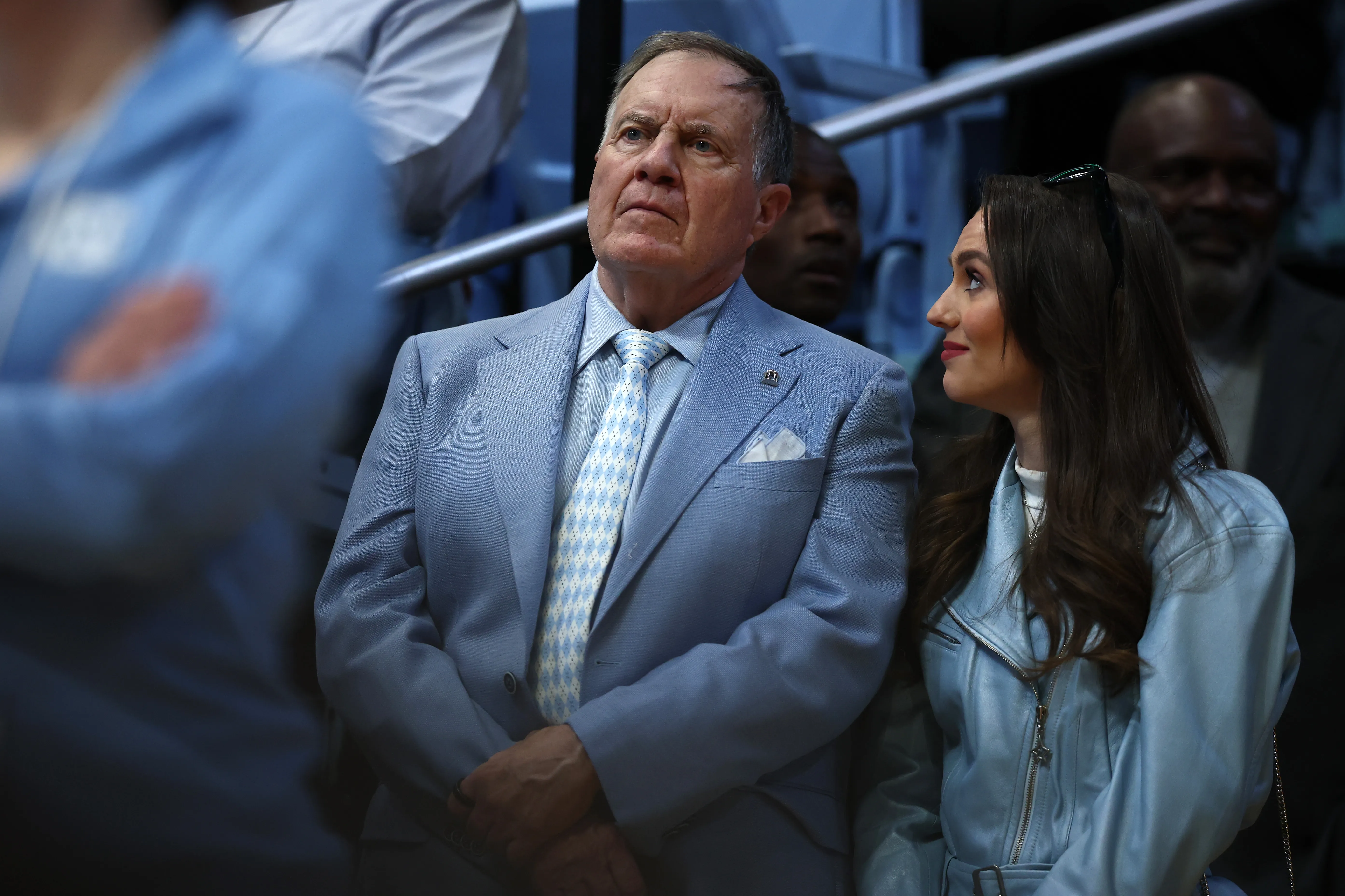 Bill Belichick and Jordon Hudson watching a basketball game.