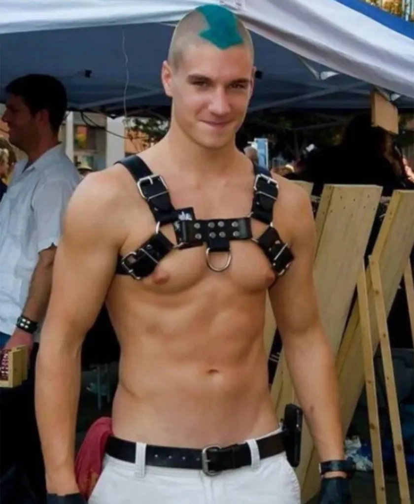 Christopher Gallant wearing a leather harness and a turquoise arrow painted on his head.