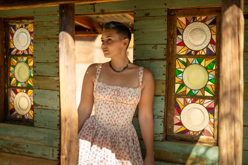 OnlyFans creator Kit Barrus in a sun dress inside a room with stained glass windows