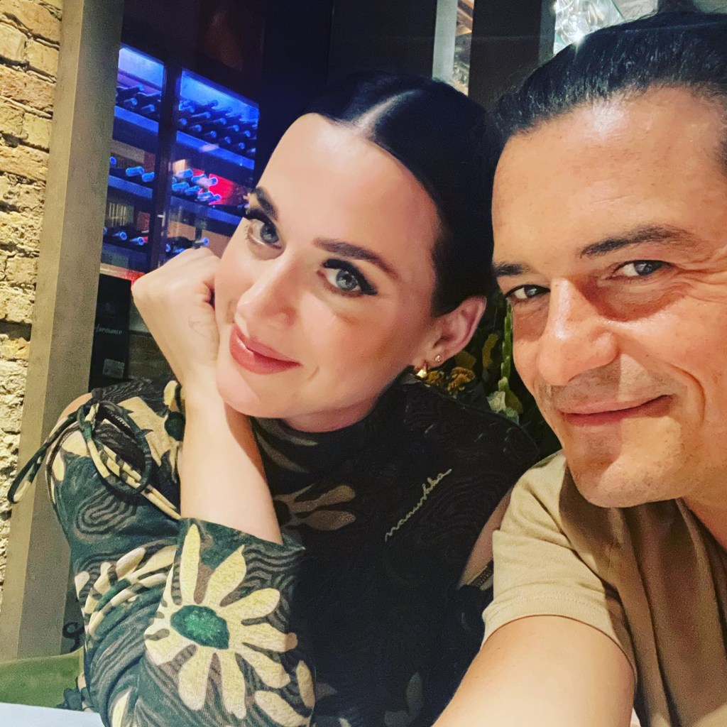 Katy Perry and Orlando Bloom smiling at the camera.