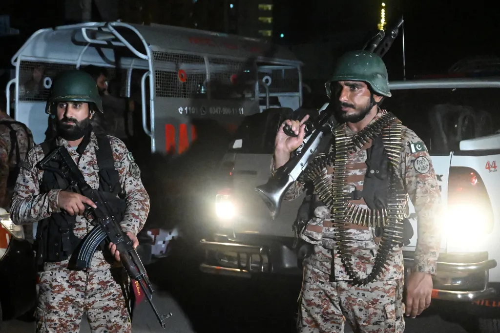 Paramilitary soldiers in camouflage with firearms, cordoning off streets after a militant attack.
