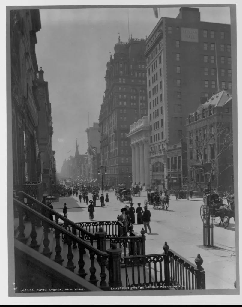 Pedestrians and horse-drawn carriages on Fifth Avenue in New York City, circa 1905.