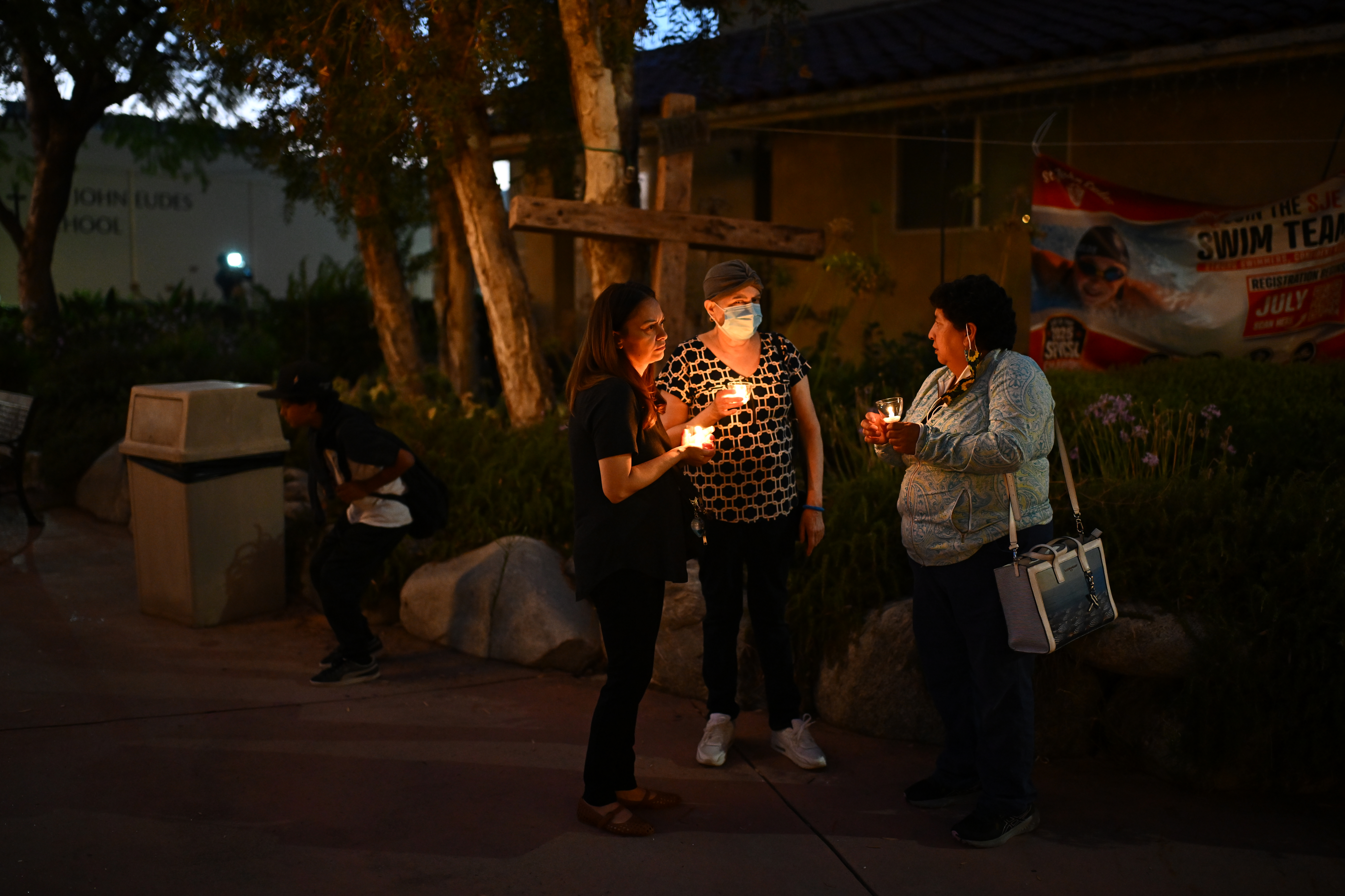 People attending a candlelight vigil for victims of a Metro bus accident and news helicopter crash.