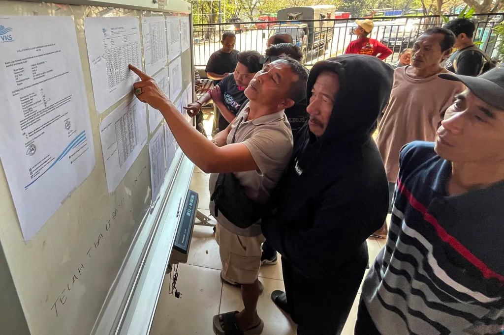 People checking the passenger manifest of a ferry.