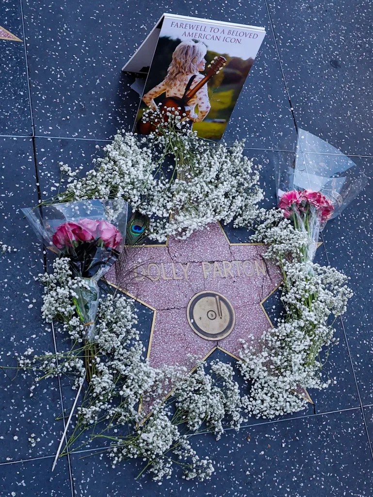 The Dolly Parton Hollywood Walk of Fame star covered in flowers and a condolence card.