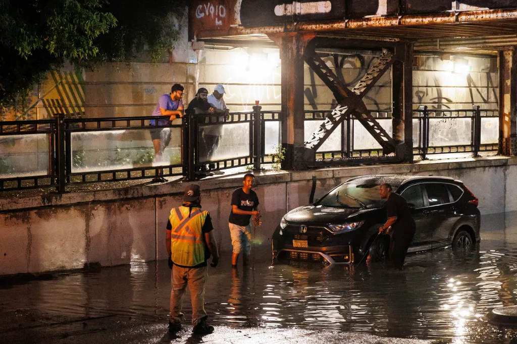 People prepare to tow a car out from a flooded underpass during a storm in Toronto.