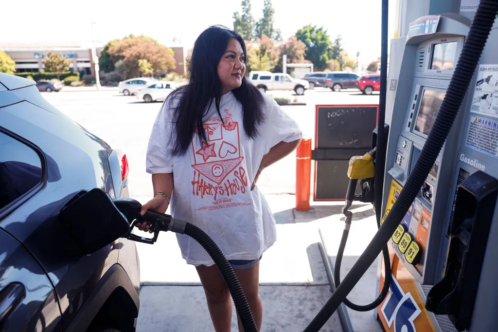 A person pumping gas into their car at a 76 gas station.