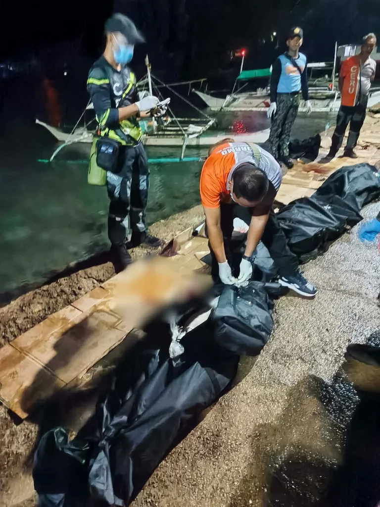 Workers zip up body bags of the victims of the ferry fire in the Philippines. 