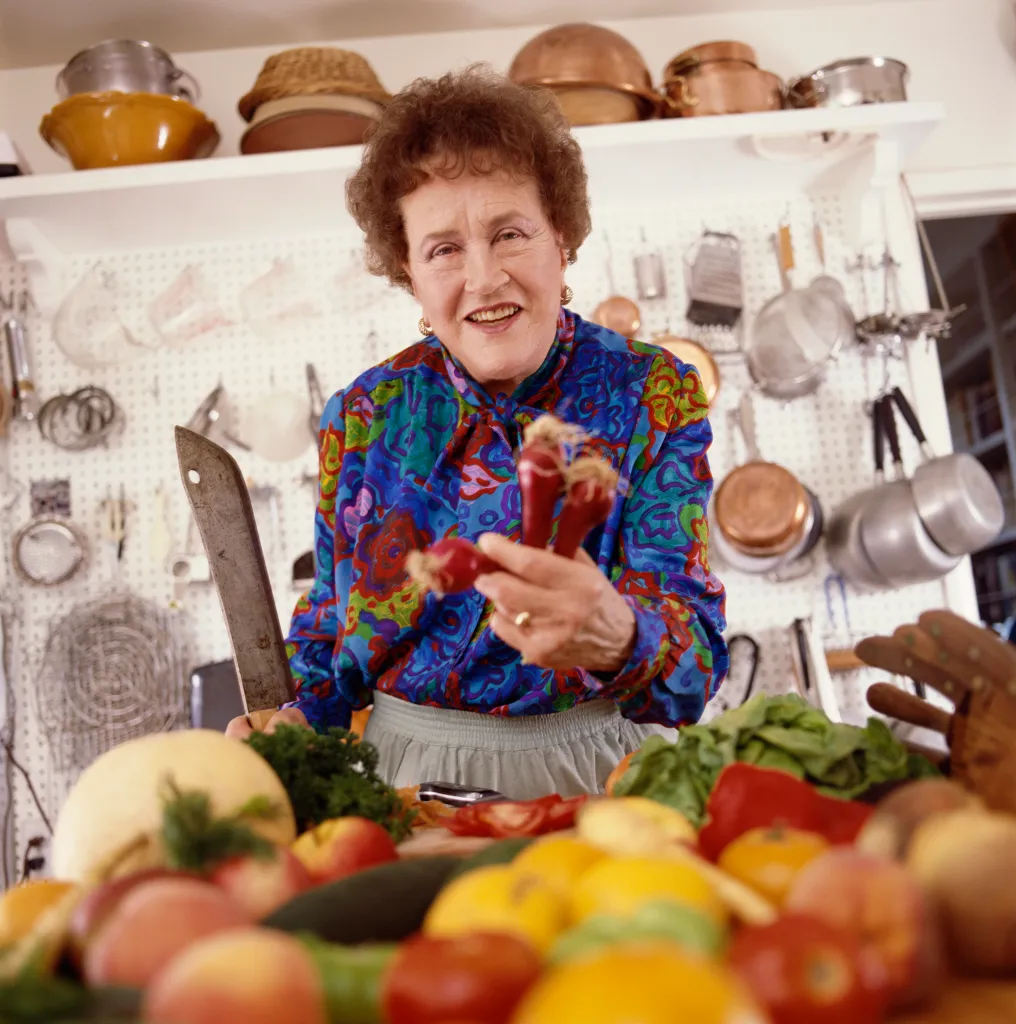 Julia Child chopping red onions in her kitchen.