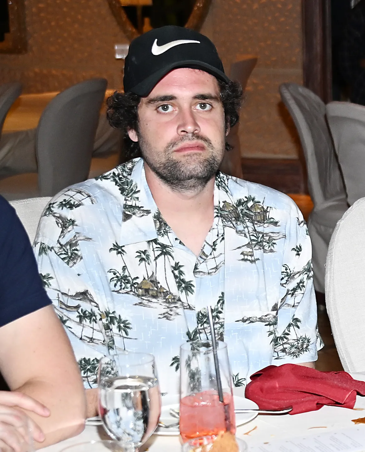 Nick Reiner wearing a Hawaiian shirt and a black baseball cap.