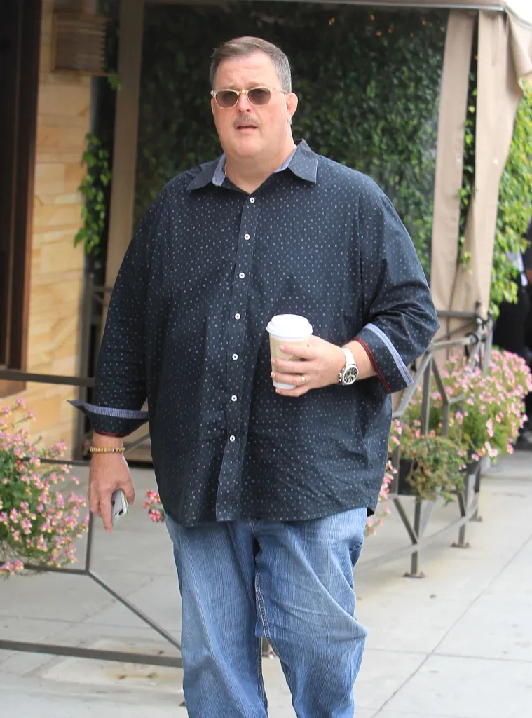 Actor Billy Gardell wearing sunglasses and holding a coffee cup.