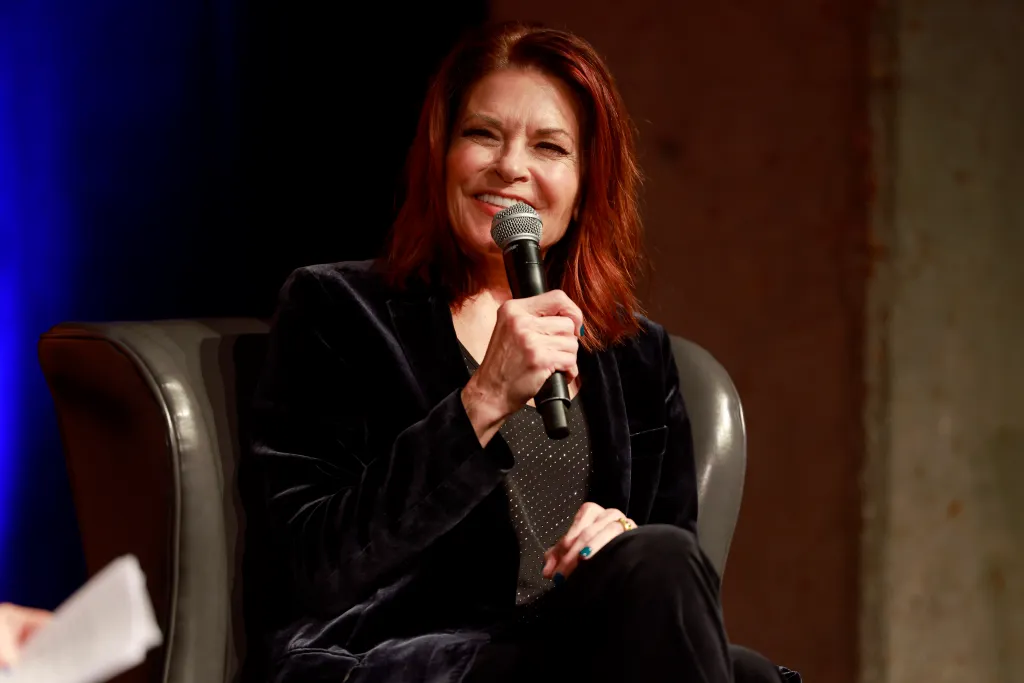 Rosanne Cash speaking into a microphone.