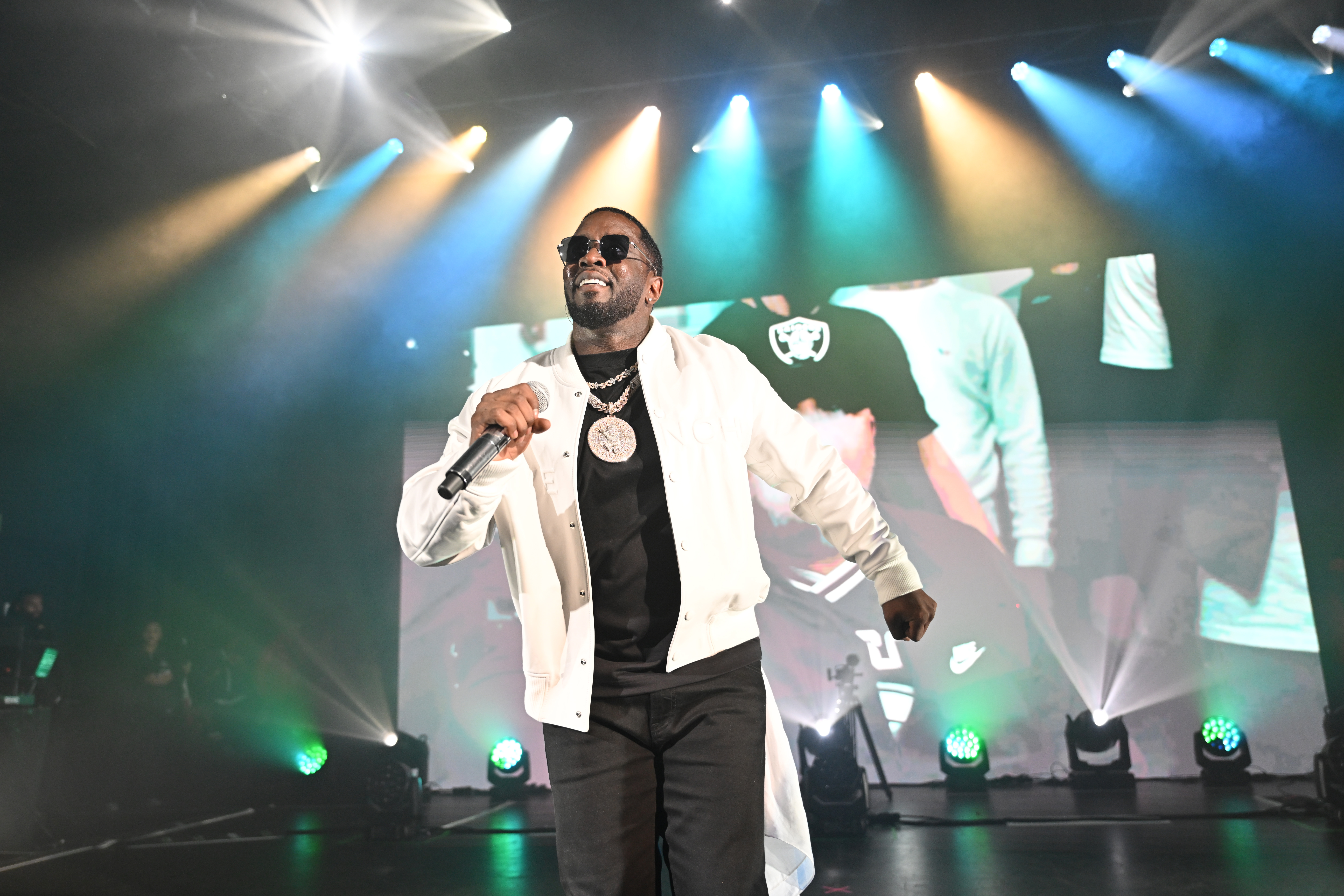 Sean Diddy Combs performing on stage, holding a microphone.