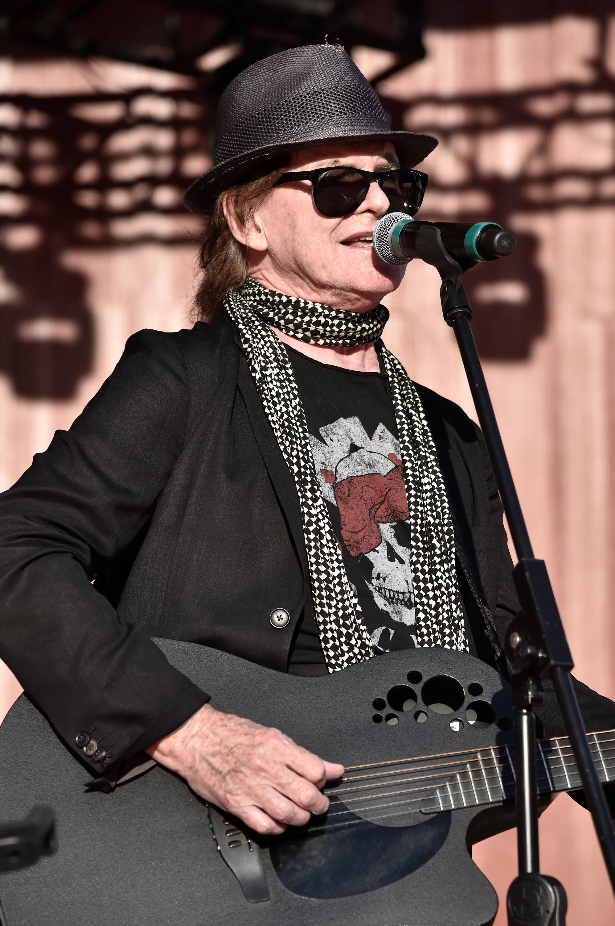 Pete Byrne of Naked Eyes performing with a black acoustic guitar.