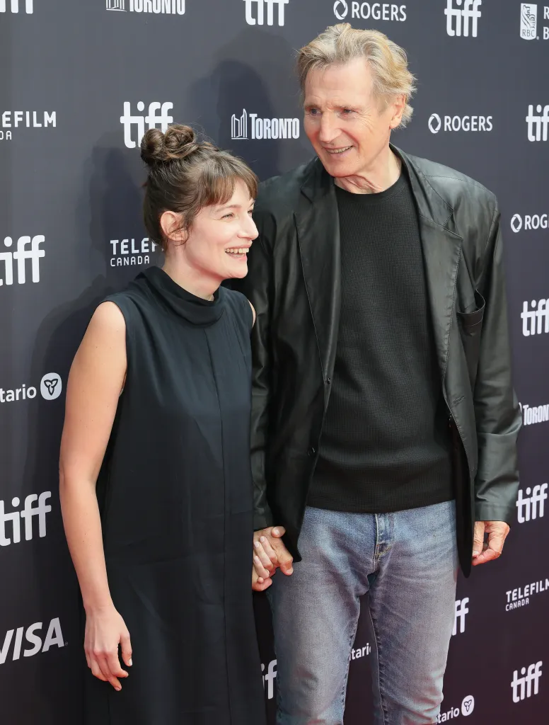 Stella Stocker and Liam Neeson holding hands and smiling at the 