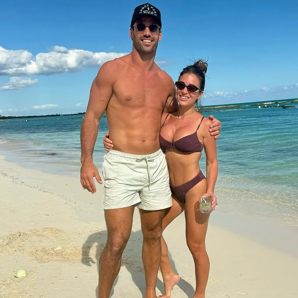 Jessie James Decker posing with a man on a beach, showing her toned body in a bikini.
