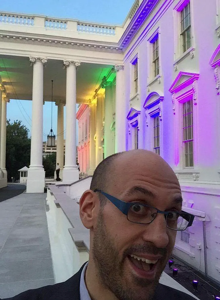 Jason Goldman taking a selfie in front of the White House lit with rainbow colors.