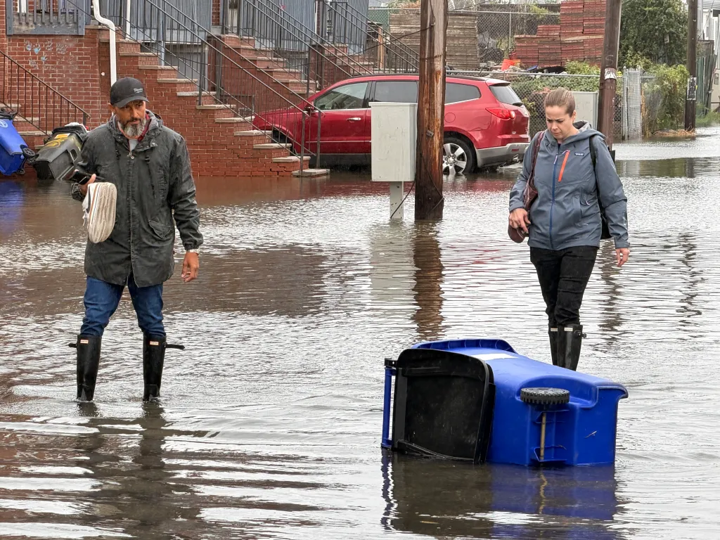 NYPD police officer Matt Langdon and his girlfriend walk through a flooded street in the Far Rockaways.