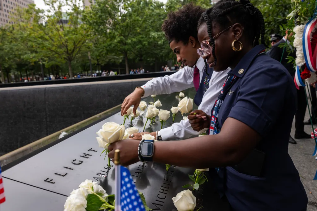 People laying flowers on the 9/11 memorial