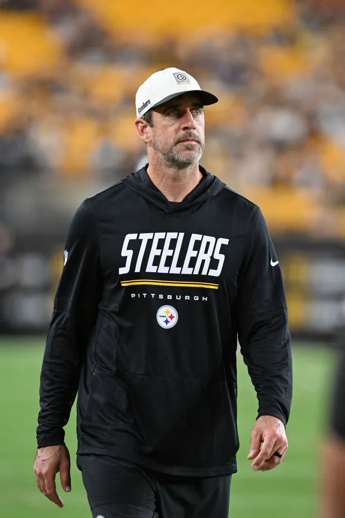 Aaron Rodgers in a Steelers hat and sweatshirt.