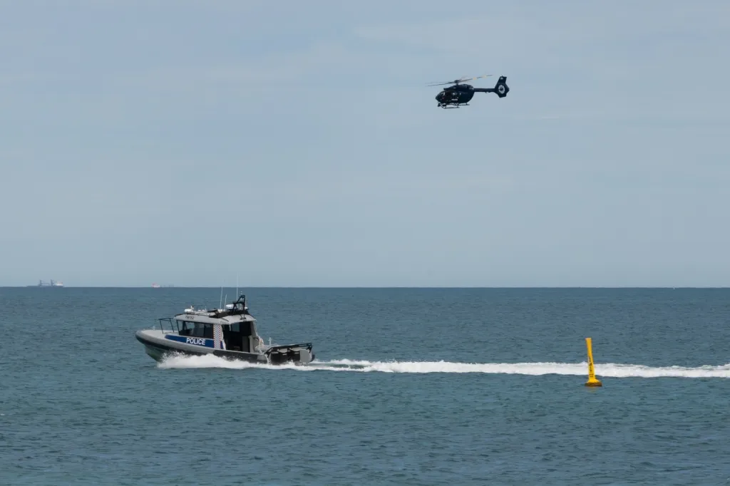 A police boat and helicopter patrol the area at Sorrento Beach in Perth, Australia on Friday.