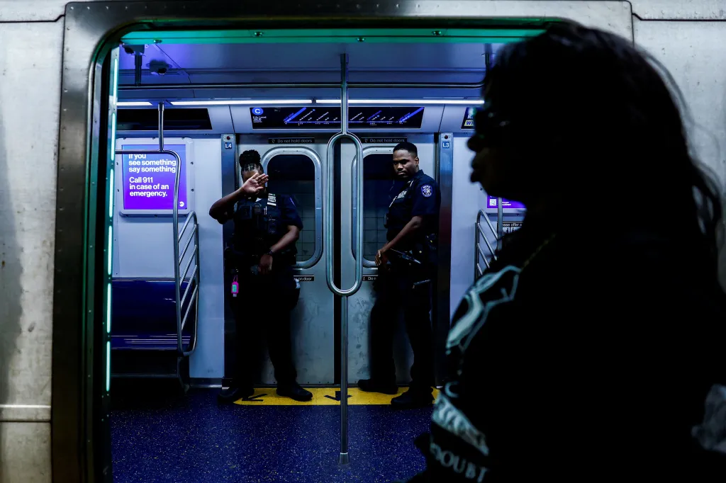 A police officer covers her face on a subway train in New York City.