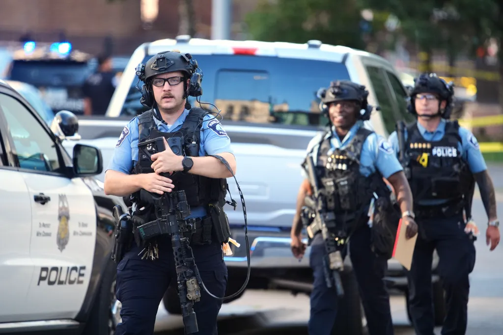 Police officers with tactical gear and rifles respond to a shooting in downtown Minneapolis.