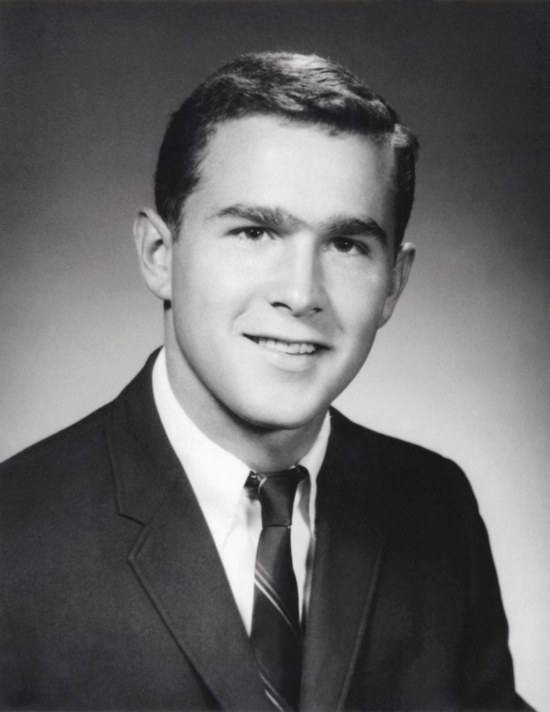 Black and white portrait of a young George W. Bush smiling.