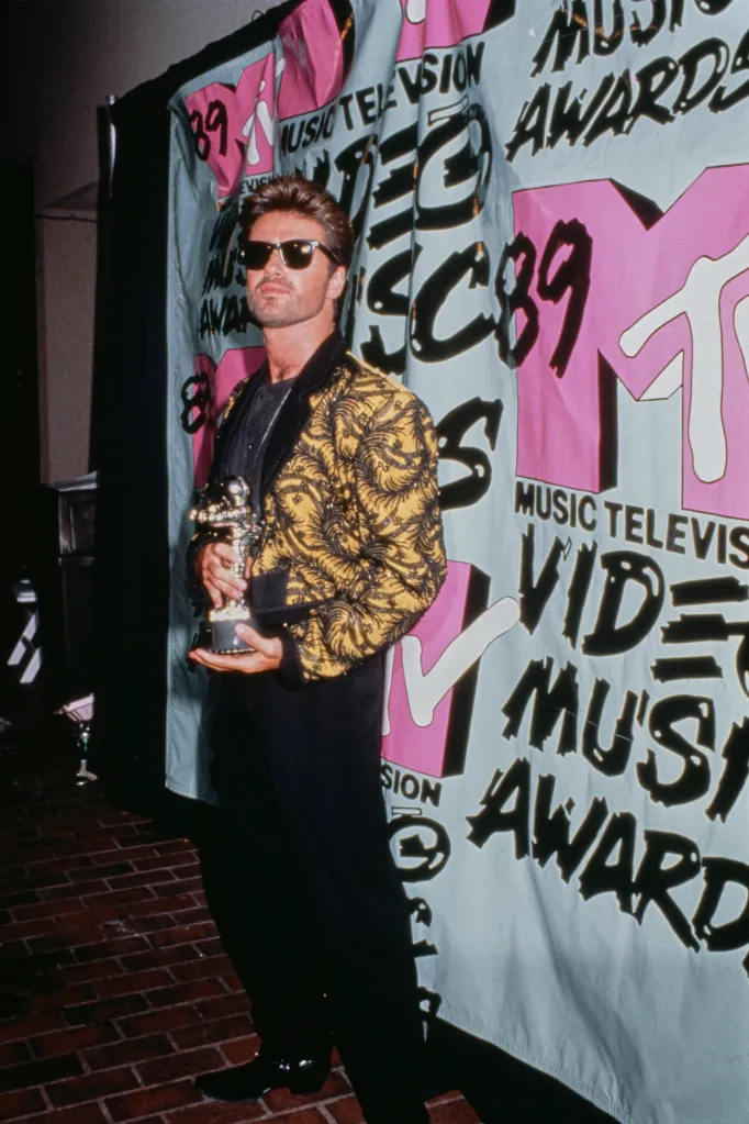 George Michael posing with the Video Vanguard award trophy at the 1989 MTV Awards.