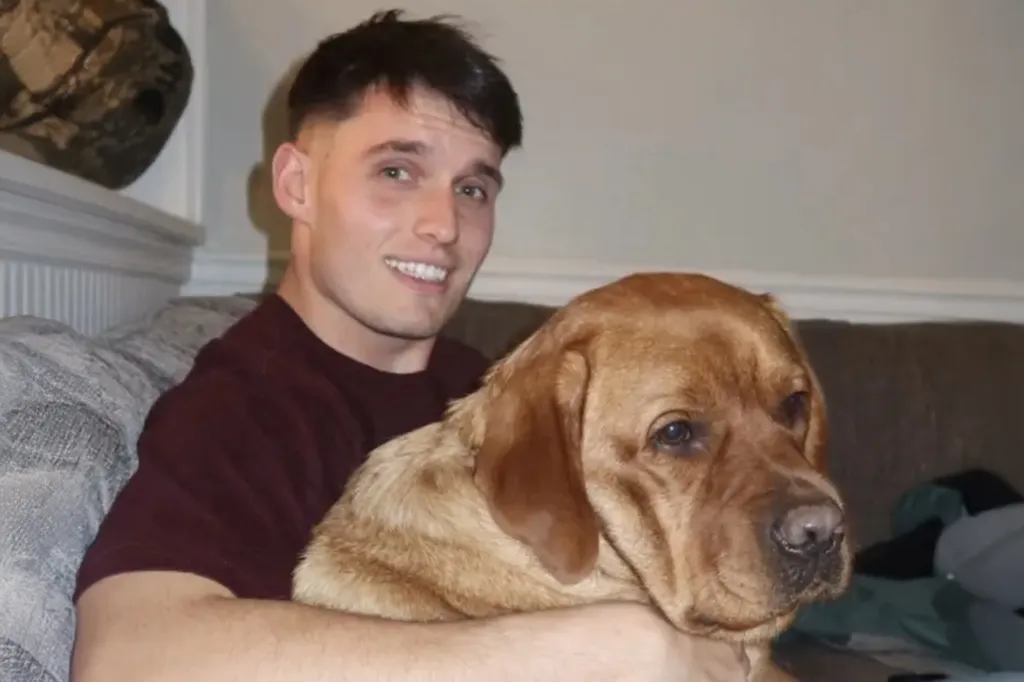 Michael T. Bereheiko smiling while holding a brown dog.
