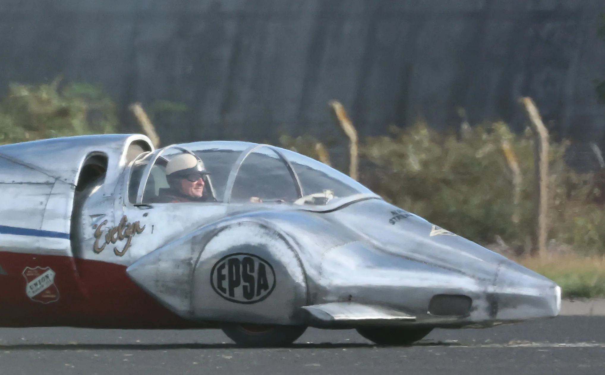Brendan Fraser in a silver and red vintage rocket car with 