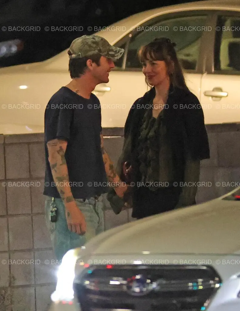 Dakota Johnson and Role Model looking at each other during a night out.
