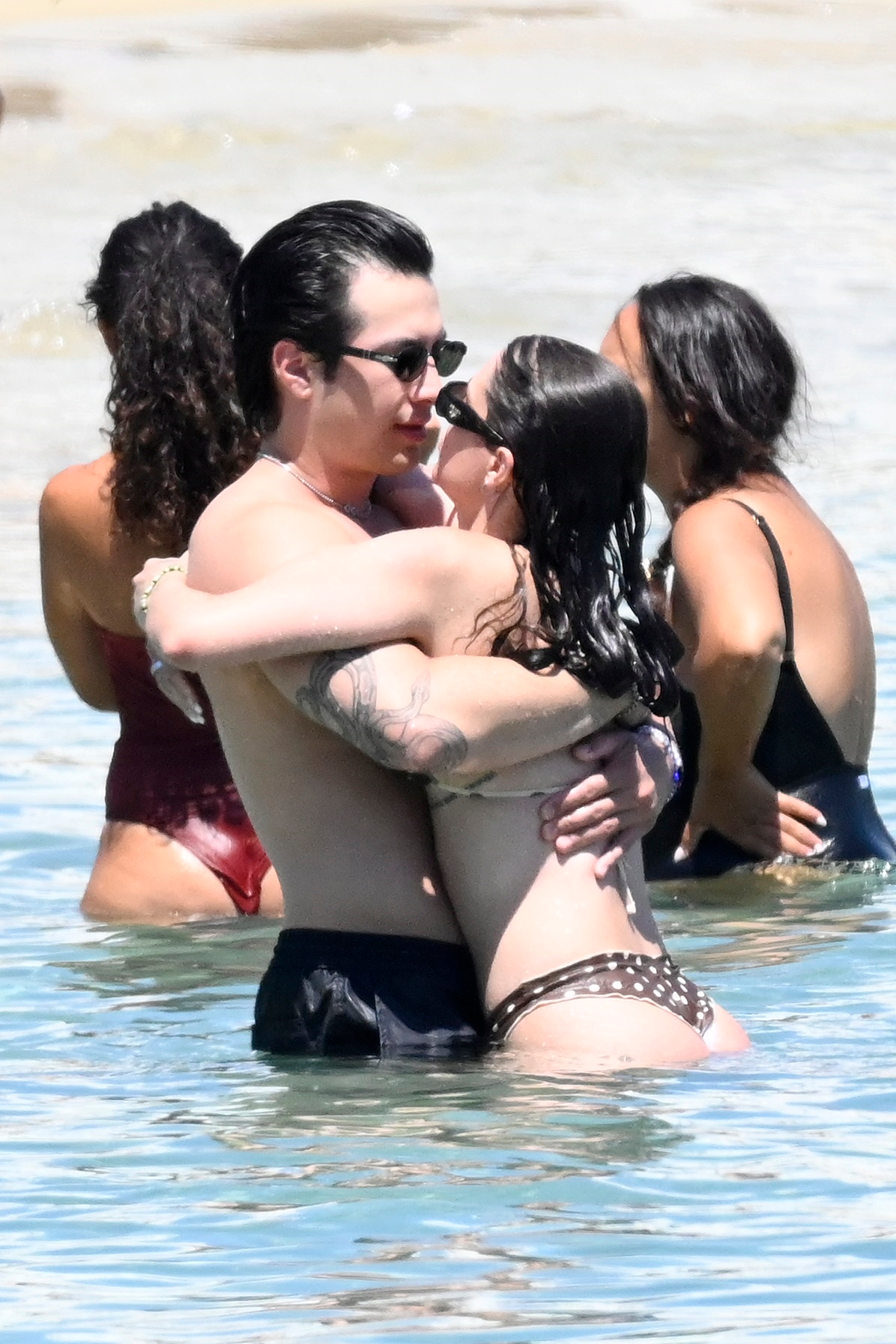Hudson Williams and Katelyn Larson embracing in the water.