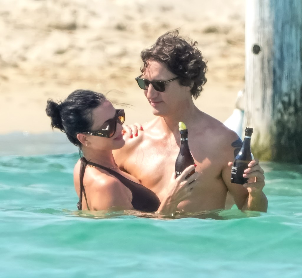 Katy Perry and Justin Trudeau enjoying a romantic day in the water, each holding a bottle of champagne.