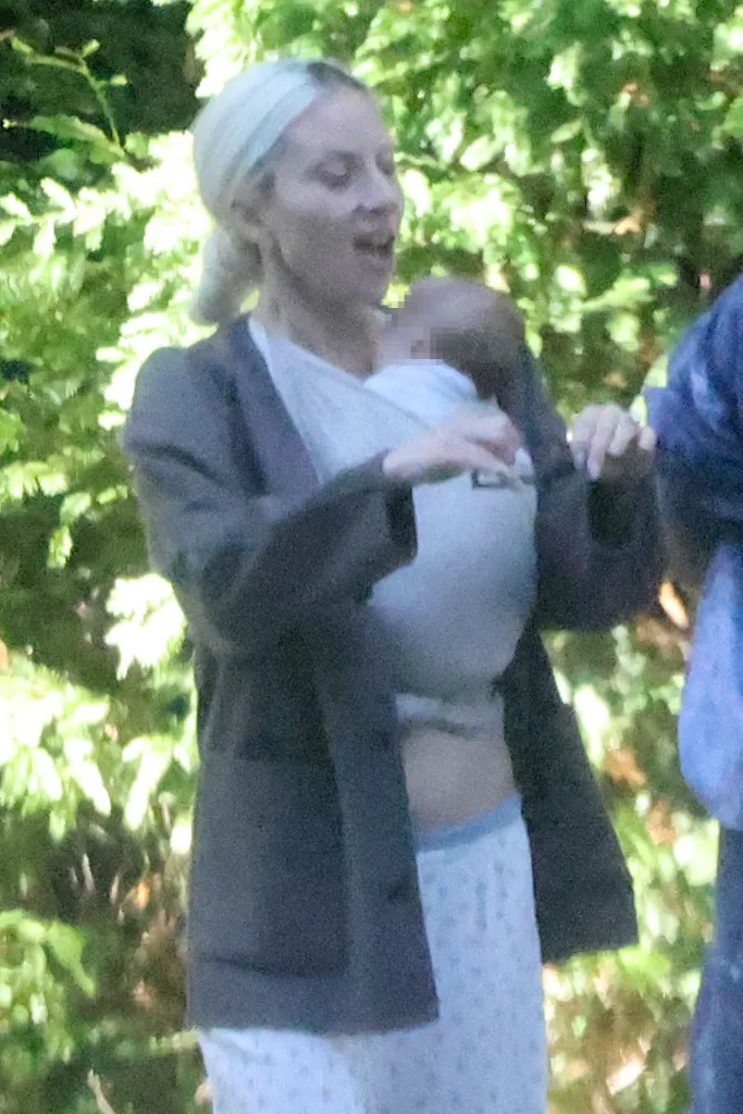 Lady Gaga enjoying a stroll with her baby in a carrier.