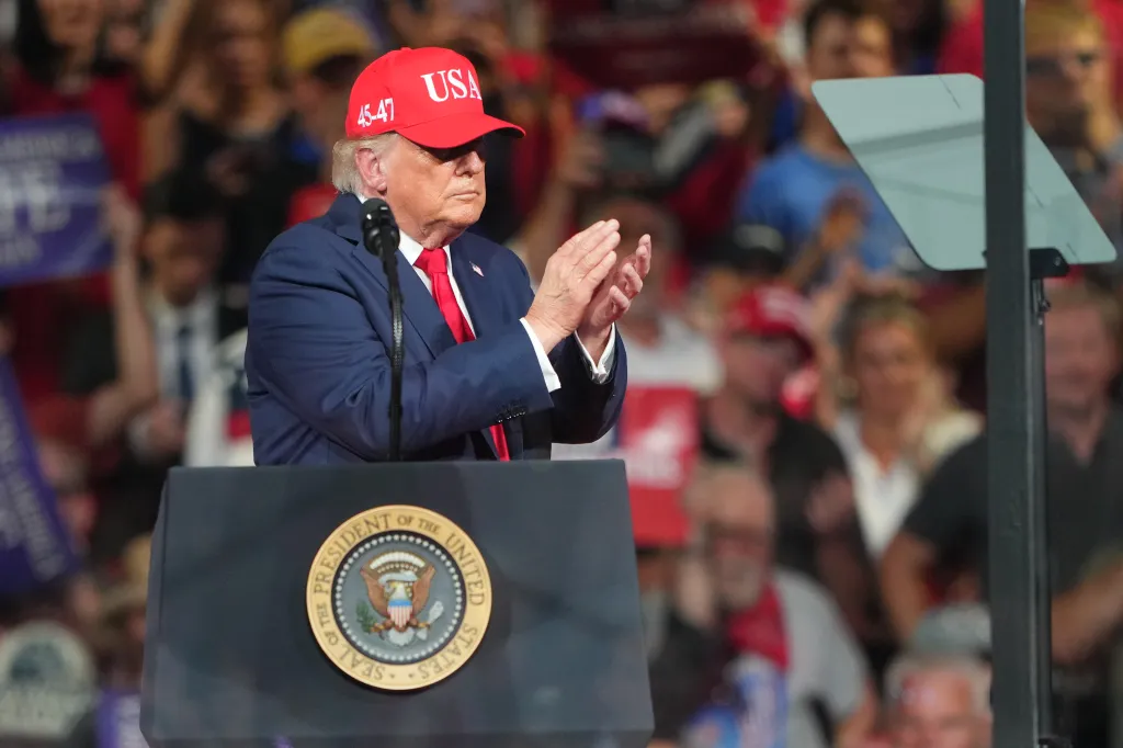 President Donald Trump applauds at a campaign rally.