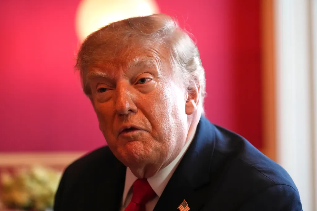 Close-up of Donald Trump looking to the left with a red background.