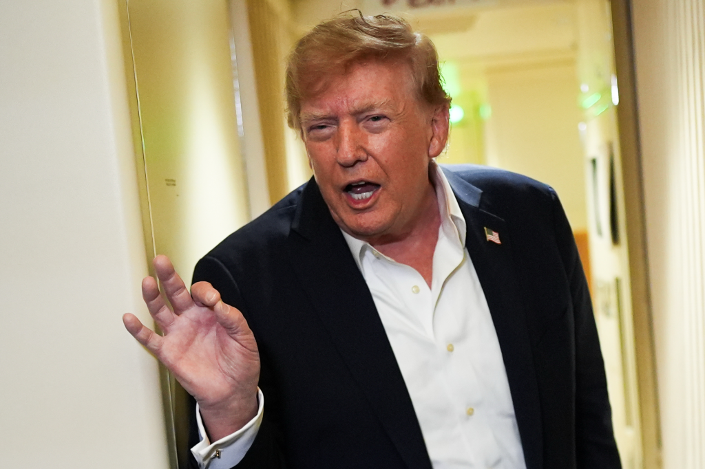 President Donald Trump speaks with reporters while in flight on Air Force One.